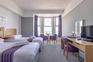 纽基贝雷斯福德酒店的酒店客房设有两张床、一张桌子和一台电视。