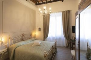 锡耶纳Casa Mavì- Siena的一间卧室配有一张带吊灯和窗户的床。