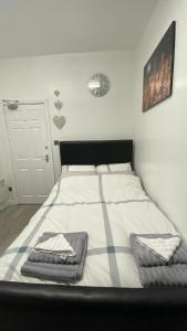 哈德斯菲尔德bvapartments-Queensgate 2的一间卧室配有一张床,上面有两条毛巾