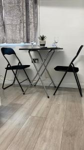 哈德斯菲尔德bvapartments-Queensgate 2的木地板间配有一张桌子和两把椅子