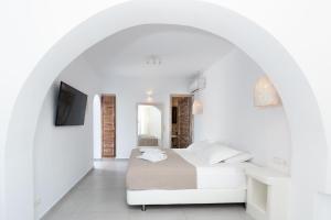 阿吉奥斯普罗科皮奥斯Naxos Sandastic的一间位于拱门上的白色卧室,配有一张床铺