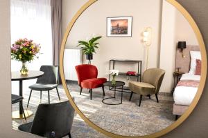 克拉科夫MR67 Mayera Rapaporta的配有椅子和床的酒店客房内的镜子