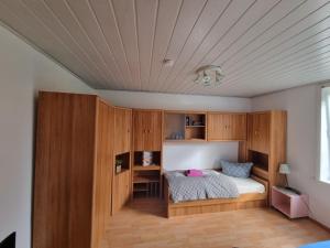 韦斯特兰Mein Urlaub auf Sylt的一间卧室配有木制橱柜和一张带书桌的床。