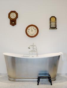 卡梅尔凡噶邦德之家精品酒店的墙上装有两把钟的浴缸