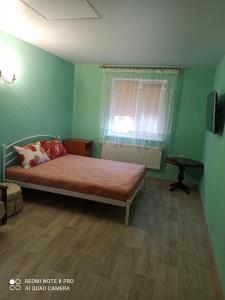 波尔塔瓦Нова квартира的绿色卧室设有床和窗户