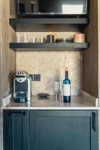 皮尔戈斯Santorini Sky, The Lodge的厨房里的柜台上摆放着一瓶葡萄酒