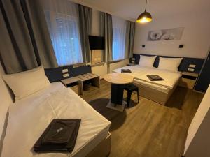 纽伦堡Hotel Central City Hbf Nürnberg的酒店客房设有两张床和一张桌子。