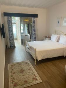 卡波布里奥雷坎托达帕萨杰姆精品酒店的卧室配有白色的床、浴缸和窗户。