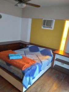 蒙特格兰德T&A RESIDENCE Aeropuerto Ezeiza的一间卧室配有一张带橙色毯子的床