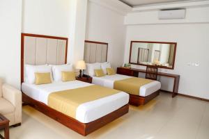 NawalaApna Colombo的酒店客房,设有两张床和镜子
