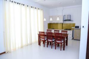 NawalaApna Colombo的厨房配有木桌和椅子