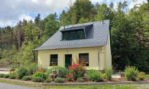 施托尔彭Ferienhaus Buschmuehle - Stolpen的一座黄色的小房子,设有太阳能屋顶
