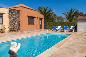 维拉韦德Villa Maravilla piscina climatizada的一个带蓝色椅子的游泳池