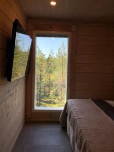 鲁卡Rokovan Helmi - Natural peace in Ruka-Kuusamo的小屋内带大窗户的卧室