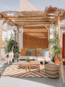 马拉加The Urban Jungle Hostel的一个带沙发和桌子的木制凉棚