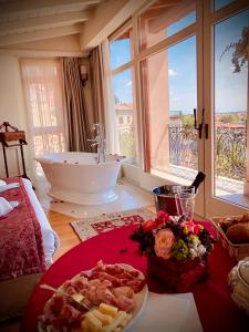 维罗纳Relais Colle San Pietro的带浴缸和一盘食物的浴室