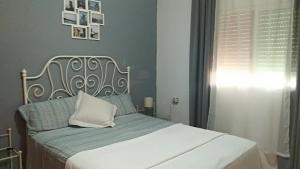 塞维利亚Vivienda Rural El Retorno的卧室配有白色的床铺和白色的枕头