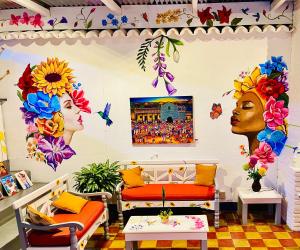 危地马拉安地瓜Hotel y Arte Antigua by Amazing Guatemala Travel的一间设有两张床的客房,墙上挂着鲜花