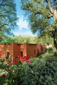 AmizmizMAROC LODGE Atlas Mountain Retreat的前方有红花的建筑