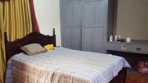 昆卡La Muralla的一间卧室配有一张带蓝色和白色棉被的床