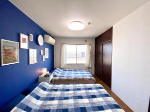 松户市松戸駅ｽｸﾞ 1DK 出張に旅行に Nomad松戸宿019的蓝色墙壁客房的两张床