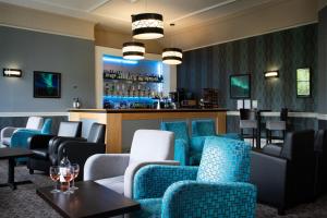 梅尔罗斯韦弗利城堡酒店的一间设有蓝色椅子的餐厅和一间酒吧