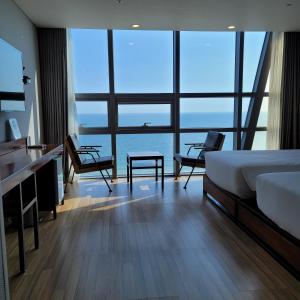 釜山海云台MS酒店的一间卧室配有一张床,享有海景