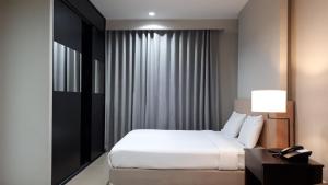 春武里J Park Hotel - SHA Extra Plus的酒店客房配有一张床和一张带台灯的书桌