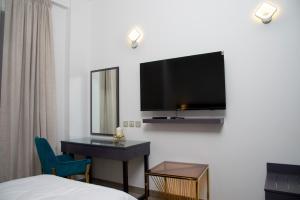 迪拜Garden City Hotel Dubai的酒店客房,设有床铺和墙上的电视