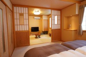 草津索美安日式旅馆的一间设有床铺和电视的房间