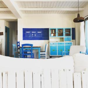 阿齐亚佩拉加saveriako, paradise for relaxed free spirits的厨房配有蓝色橱柜和桌椅