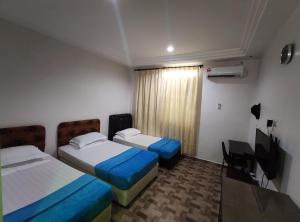克提DARUL SALAM INN HOTEL的酒店客房设有两张床和电视。