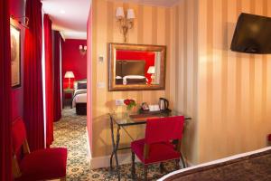 巴黎双大陆酒店的一间设有红色椅子和一张带镜子的桌子的房间