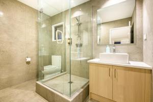 奥克兰塔卡普纳国际汽车旅馆的一间带玻璃淋浴和水槽的浴室