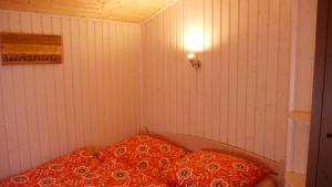 SilberstedtFerienhaus Stolley的小房间,配有一张带红色枕头的床