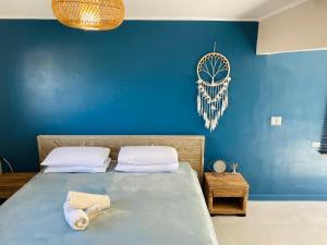 棕榈滩阿鲁巴酒店的一间卧室设有蓝色的墙壁和一张带毛巾的床。