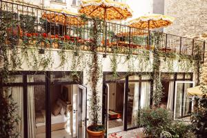 巴黎Hôtel Monsieur Aristide的大楼内的阳台,配有植物和遮阳伞
