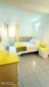法塔加Casa Reyes Fataga Apta Reyes的一间卧室配有一张床和一张黄色的桌子