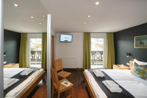 滨湖采尔Seehotel Sissi的一间卧室设有两张床和两个窗户。