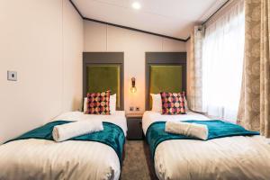 ThorntonBushmills Lodge with Hot Tub的带窗户的客房内设有两张单人床。