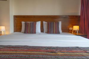 安曼安曼安蒂卡酒店的一张带两个枕头的大床和木制床头板