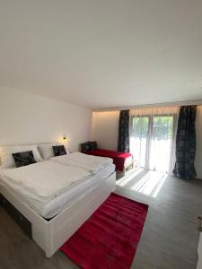 圣奥斯瓦尔德Apartment GRANAT的卧室配有白色的床和红色地毯。