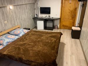 特维尔Sitara Hostel的一间卧室配有一张床、一张桌子和一只狗