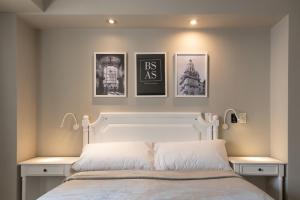 布宜诺斯艾利斯Up América Plaza的卧室配有一张墙上三幅照片的床