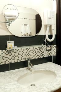 罗马罗马度假村酒店的浴室设有白色水槽和镜子
