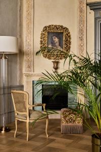 克拉科夫Hotel H15 Luxury Palace的客厅配有椅子和墙上的肖像