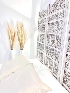 圣艾蒂安L’Escale - Le Boho + garage + NETFLIX的一间卧室配有一张白色的床和两瓶植物花瓶