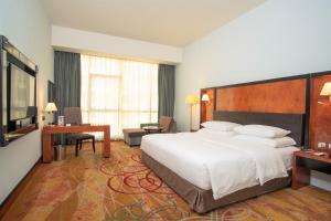 迪拜Millennium Airport Hotel Dubai的酒店客房设有一张大床和一张书桌。