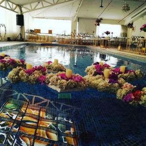 利雅德Millennia Olaya Hotel的游泳池里放着鲜花和蜡烛