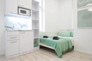 布达佩斯布达佩斯和谐度假公寓的一间白色的小卧室,配有床和微波炉